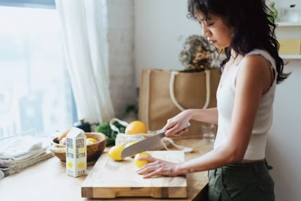 donna che taglia un limone in cucina